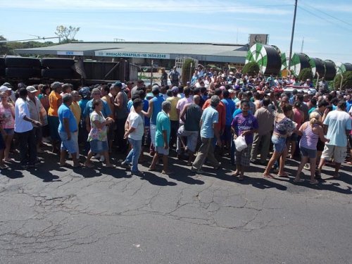 Carreta com frango tomba e população tenta saquear carga
